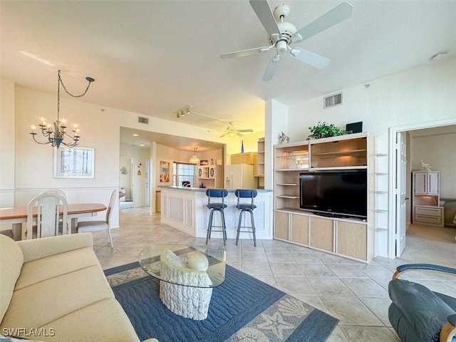 tiled living room featuring ceiling fan with notable chandelier