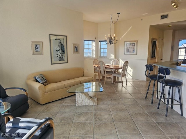 living room featuring light tile patterned floors and an inviting chandelier