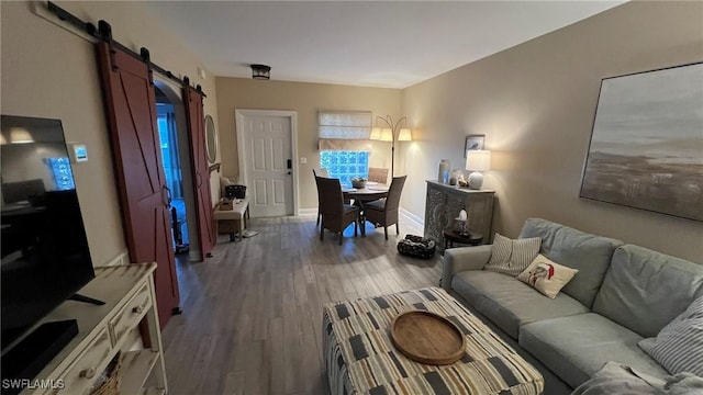 living room featuring a barn door and hardwood / wood-style flooring