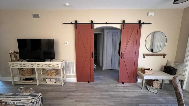 interior space with wood-type flooring and a barn door