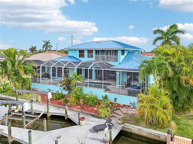 rear view of property with a pool, glass enclosure, and a patio