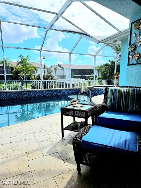 view of pool with glass enclosure and a patio area