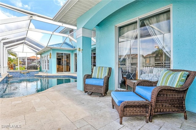 view of swimming pool featuring a hot tub, glass enclosure, and a patio area