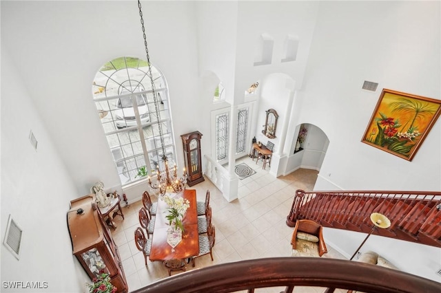 living room with a high ceiling, light tile patterned floors, and plenty of natural light