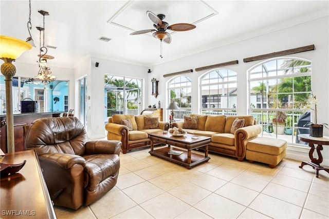 living room featuring ceiling fan with notable chandelier, ornamental molding, and light tile patterned floors