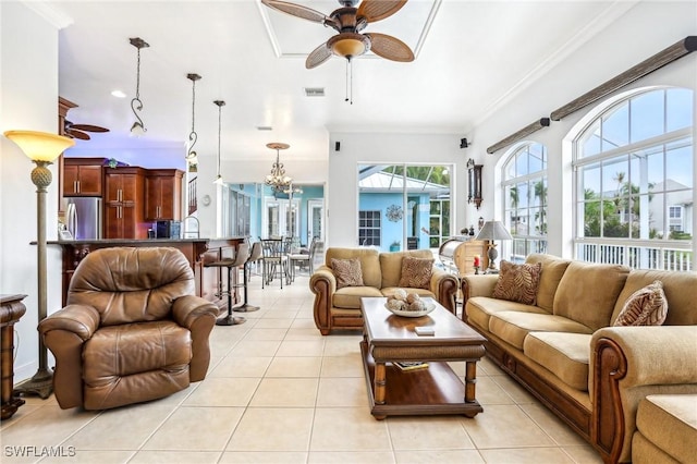 living room featuring ceiling fan with notable chandelier, sink, light tile patterned floors, and crown molding