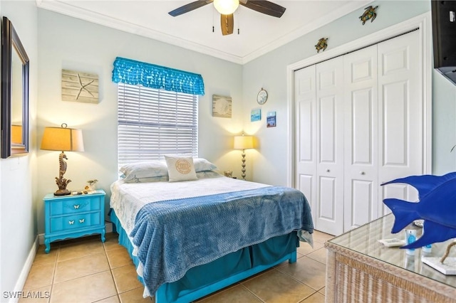 bedroom with tile patterned floors, a closet, ceiling fan, and ornamental molding