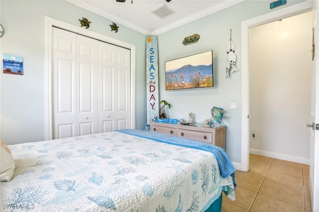 bedroom with ornamental molding, a closet, and light tile patterned floors