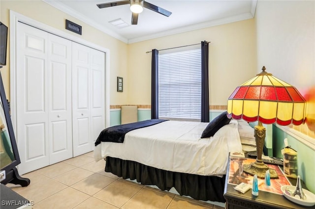 tiled bedroom with ceiling fan, crown molding, and a closet