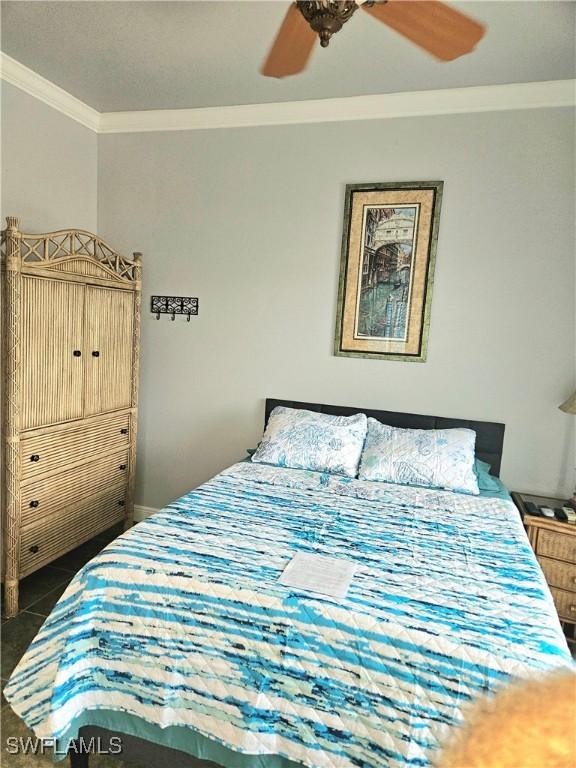 tiled bedroom featuring ornamental molding and ceiling fan