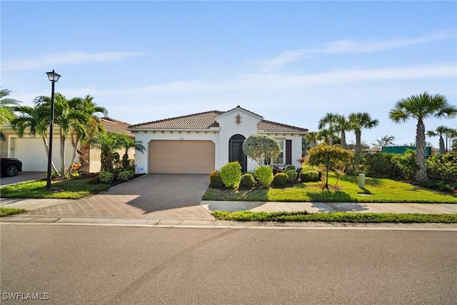 mediterranean / spanish-style house featuring a front yard and a garage