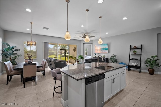 kitchen featuring white cabinets, dark stone counters, sink, a center island with sink, and dishwasher