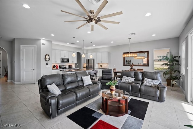 living room featuring ceiling fan, light tile patterned flooring, and sink