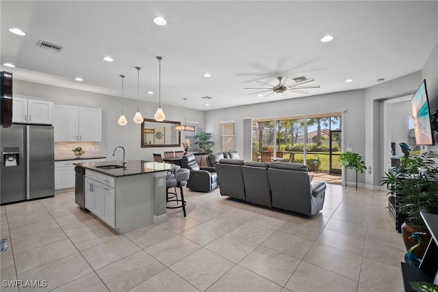 kitchen with a center island with sink, white cabinetry, sink, and appliances with stainless steel finishes