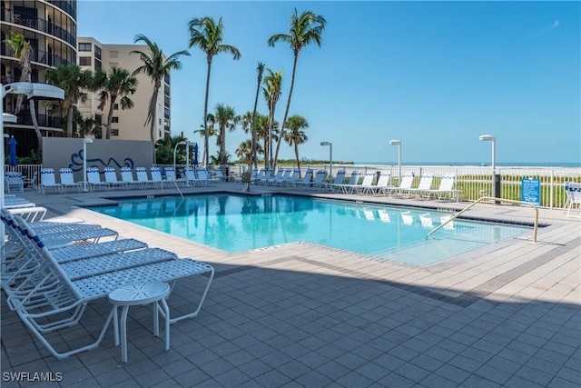 view of pool with a patio area and a water view