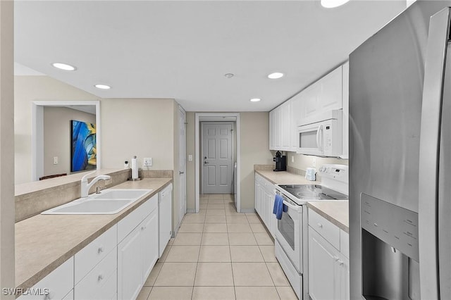 kitchen with white cabinets, light tile patterned floors, white appliances, and sink