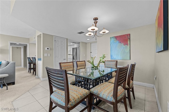 dining area with light tile patterned flooring and a notable chandelier