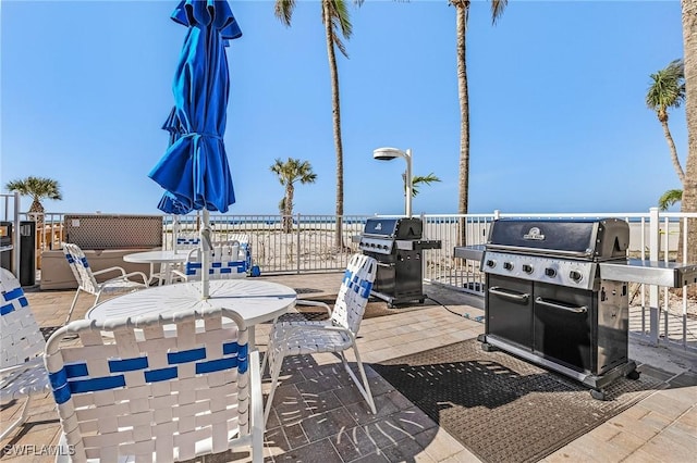 view of patio with area for grilling and a water view