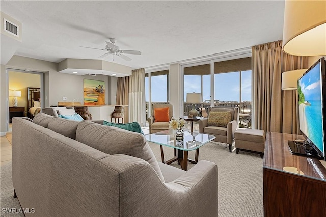 living room with ceiling fan and expansive windows