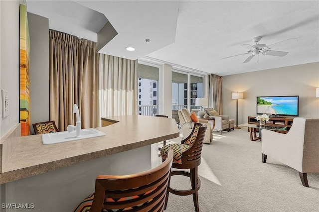 dining area featuring carpet flooring, floor to ceiling windows, ceiling fan, and sink