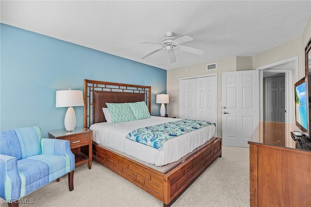 bedroom featuring ceiling fan, light carpet, and a closet