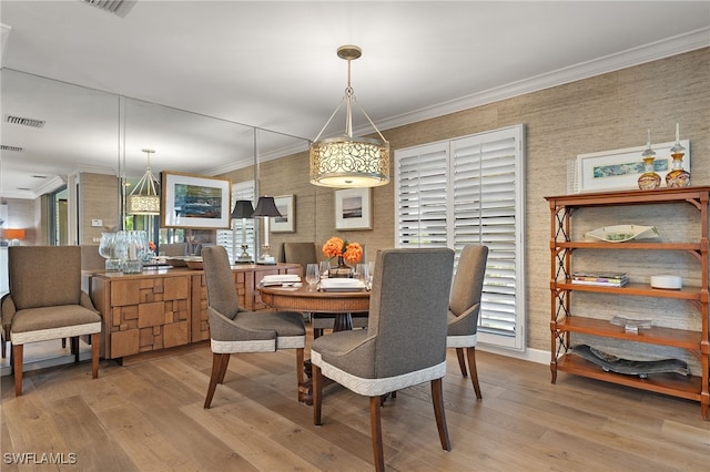 dining space with light wood-type flooring, plenty of natural light, and ornamental molding