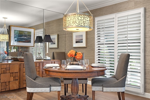 dining area featuring hardwood / wood-style flooring and crown molding