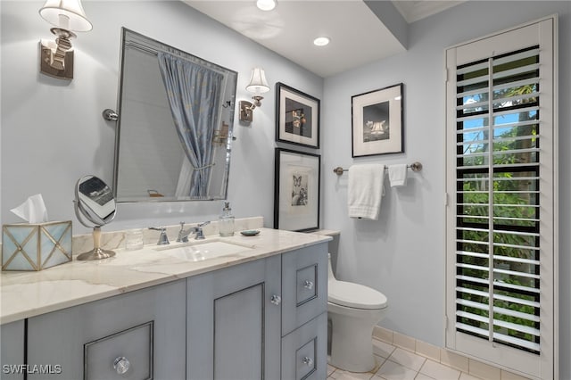 bathroom with toilet, vanity, and tile patterned floors