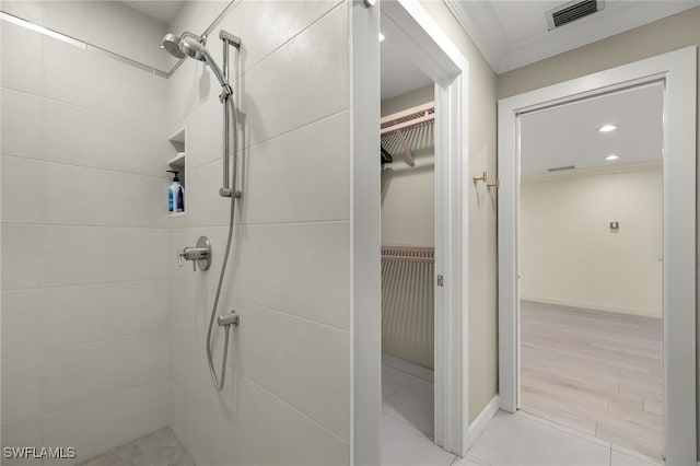 bathroom featuring tiled shower and ornamental molding