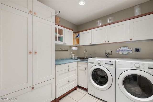 washroom featuring light tile patterned flooring, cabinets, sink, and washing machine and dryer