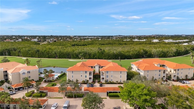 drone / aerial view with a water view, golf course view, and a wooded view