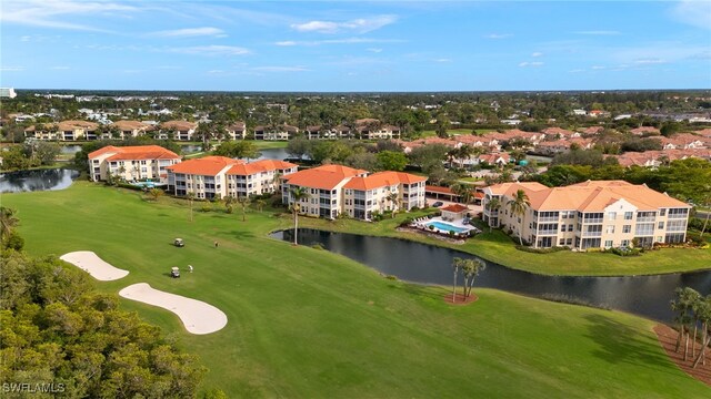 drone / aerial view with view of golf course and a water view