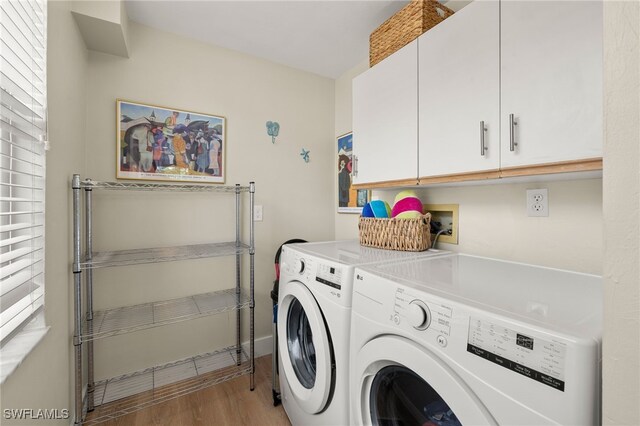 laundry area featuring baseboards, independent washer and dryer, cabinet space, and light wood-style floors