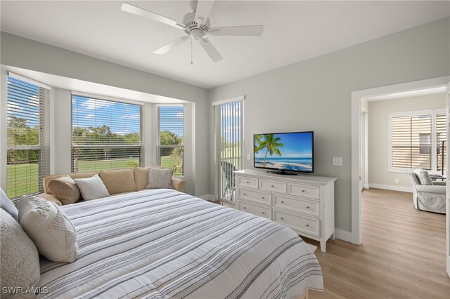 bedroom with light wood-type flooring, baseboards, and a ceiling fan