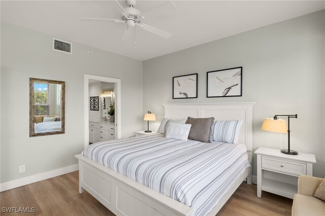 bedroom featuring visible vents, ensuite bath, light wood-style flooring, and baseboards