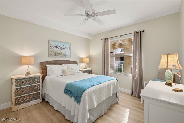 bedroom featuring light wood finished floors, a ceiling fan, and baseboards