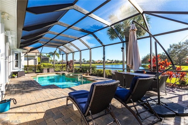 view of pool with a lanai, a patio area, and a water view