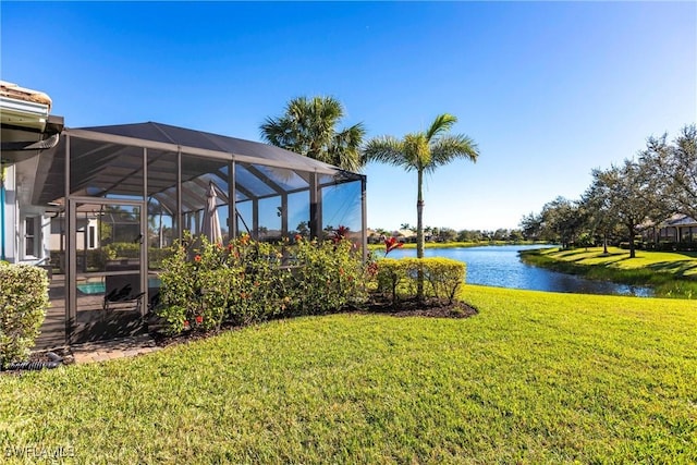 view of yard with a lanai and a water view