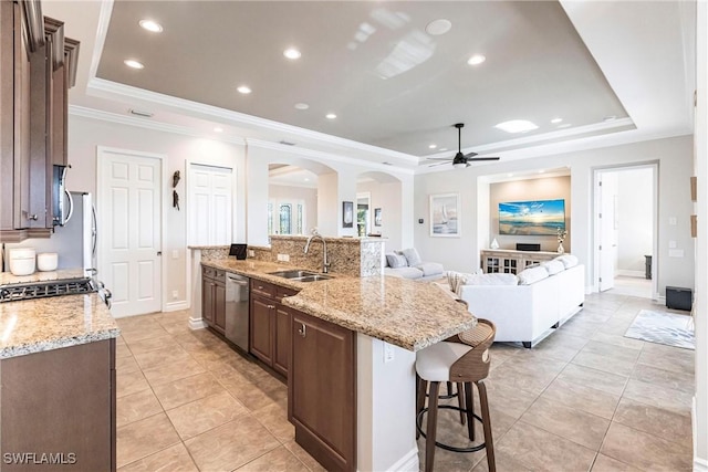 kitchen with a spacious island, a raised ceiling, and sink