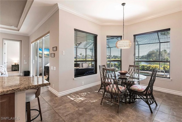 dining room with dark tile patterned floors and crown molding