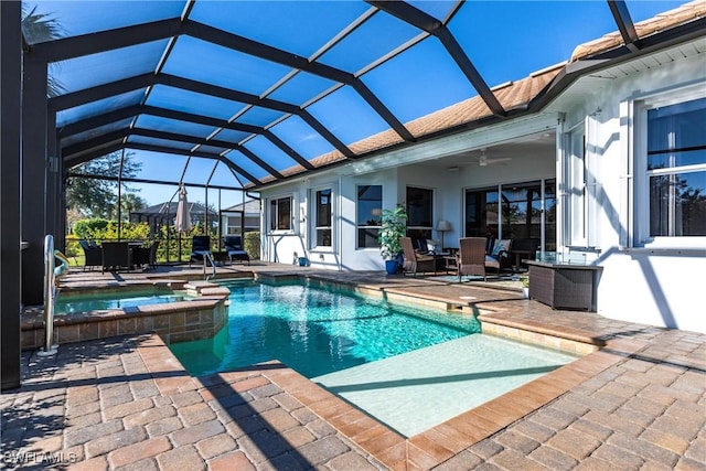 view of pool with ceiling fan, a patio area, a lanai, and an in ground hot tub