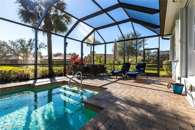 view of pool featuring glass enclosure and a patio area