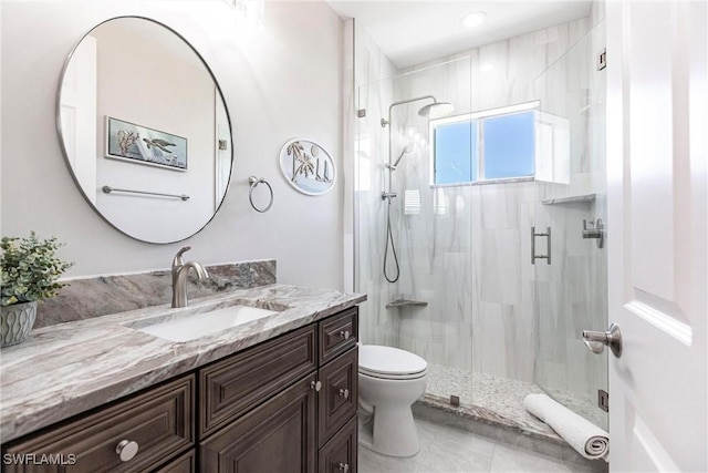 bathroom with a shower with door, vanity, and toilet