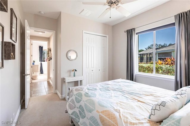 bedroom featuring ceiling fan, light carpet, and a closet