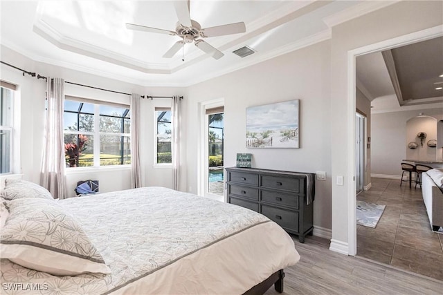 bedroom featuring ceiling fan, crown molding, access to outside, and a tray ceiling