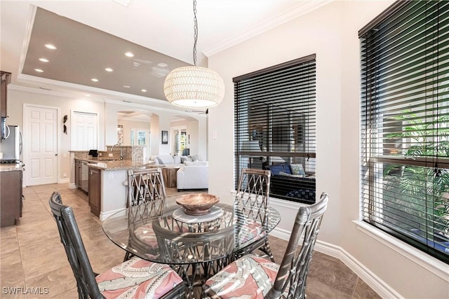 dining area with sink, light tile patterned floors, and ornamental molding