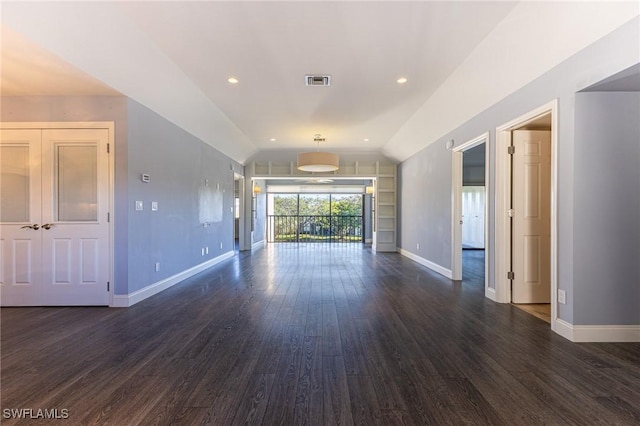 unfurnished living room with dark wood-type flooring and vaulted ceiling