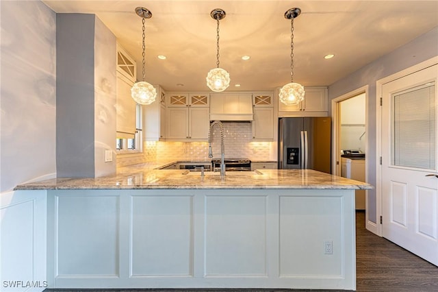 kitchen with kitchen peninsula, decorative light fixtures, stainless steel refrigerator with ice dispenser, light stone counters, and white cabinets