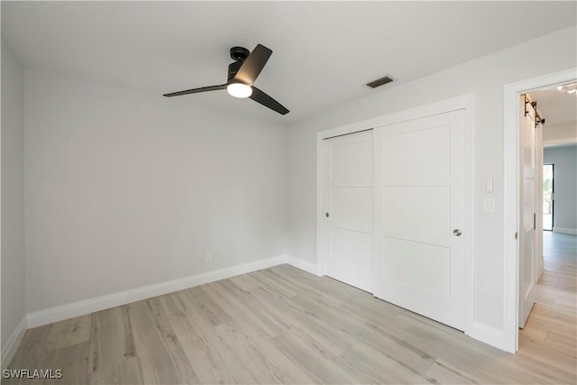 unfurnished bedroom featuring visible vents, baseboards, ceiling fan, light wood-style floors, and a closet