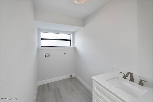 laundry room with washer hookup, a sink, electric dryer hookup, light wood-type flooring, and baseboards